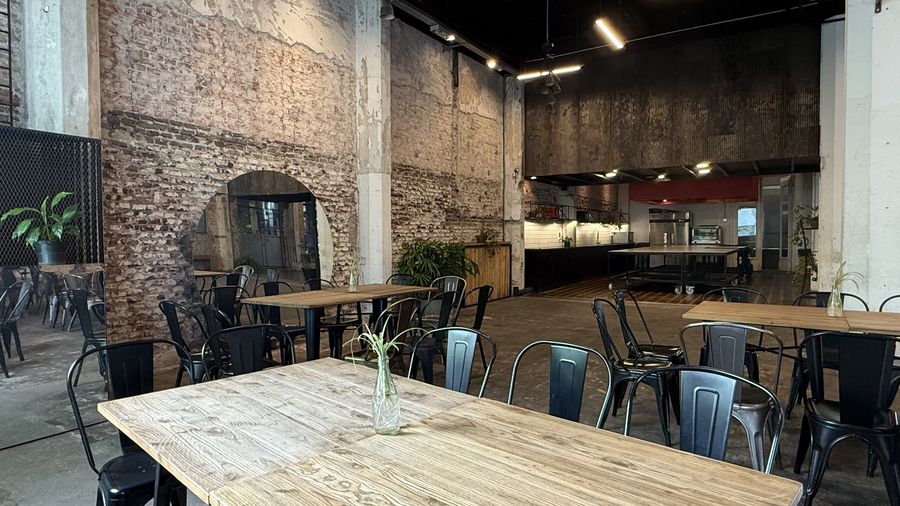 Salón de Flex con mesas de madera y sillas, listo para una celebración privada