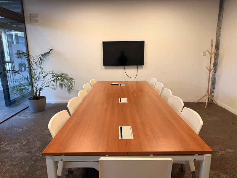 Sala de reunión de Flex con mesa larga y pantalla