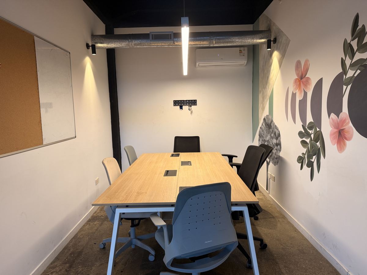 Sala de reunión chica con mesa de trabajo y pizarra
