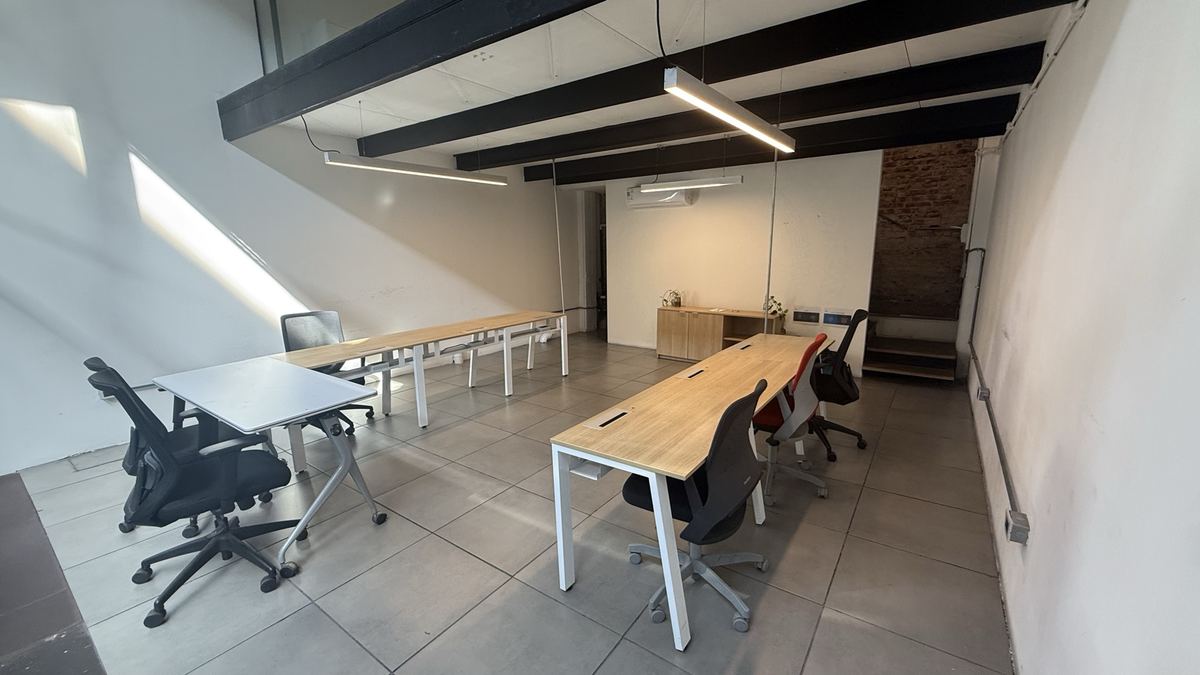 Oficina mediana con puestos de trabajo y mesa de reunión